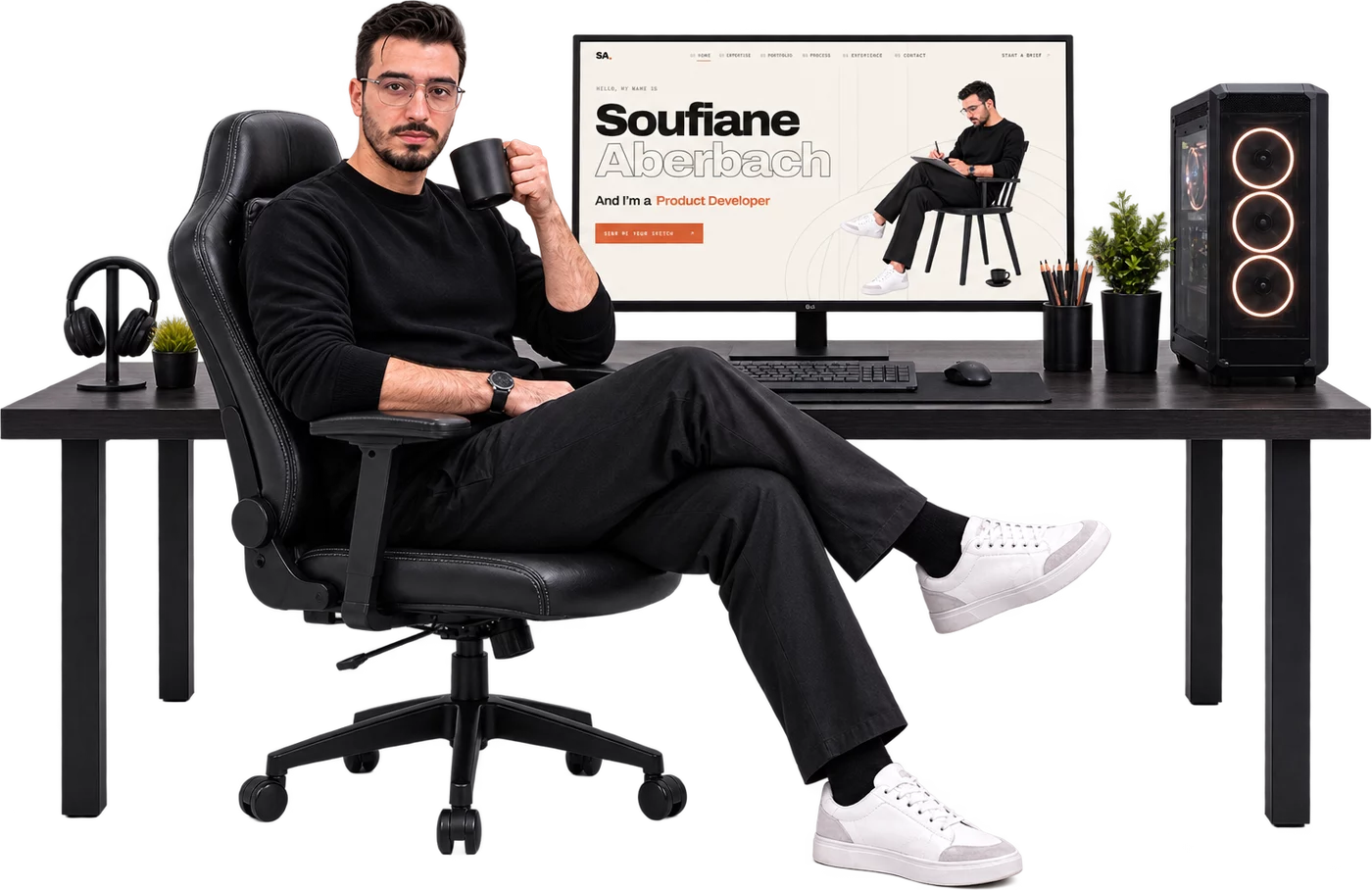 Soufiane Aberbach at his desk beside a monitor displaying his current portfolio website