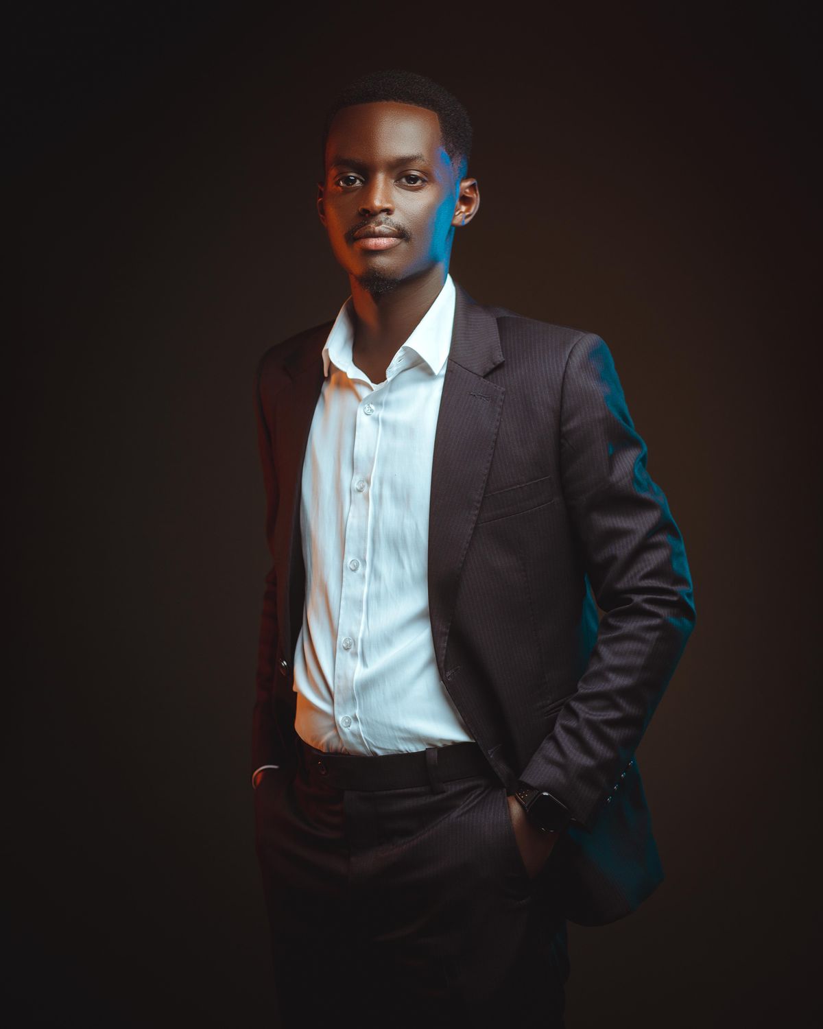 Man wearing a dark suit and open white shirt.