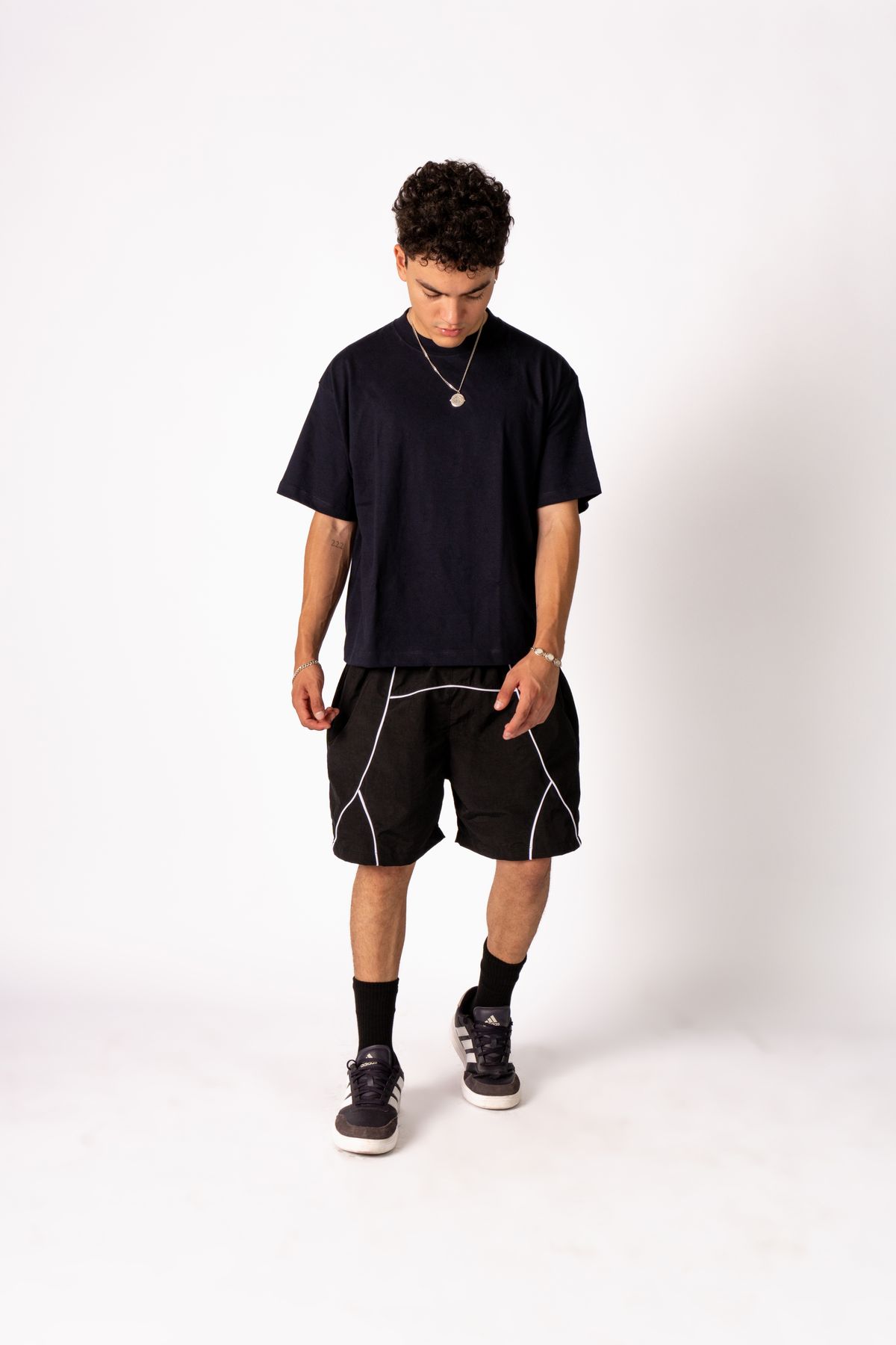 Full-length studio photograph of a man in a black T-shirt and shorts.
