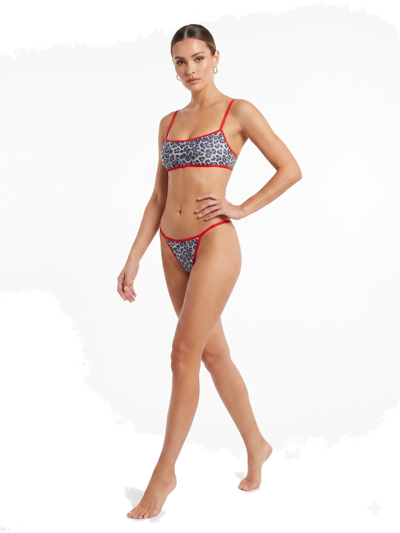 A printed bikini with contrast red trim and thin straps, photographed on a white studio ground.